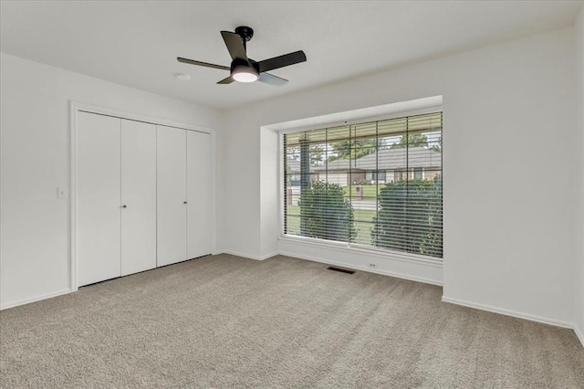 unfurnished bedroom featuring ceiling fan, a closet, and carpet