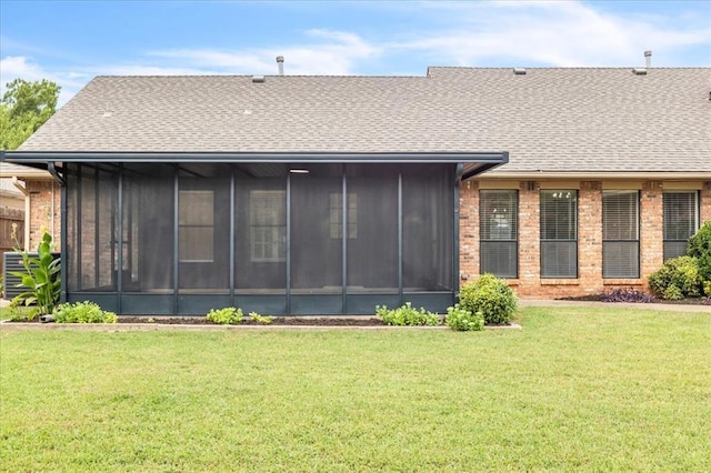 back of property with a yard and a sunroom