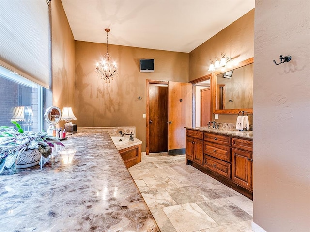 bathroom featuring a bathing tub, vanity, and a notable chandelier