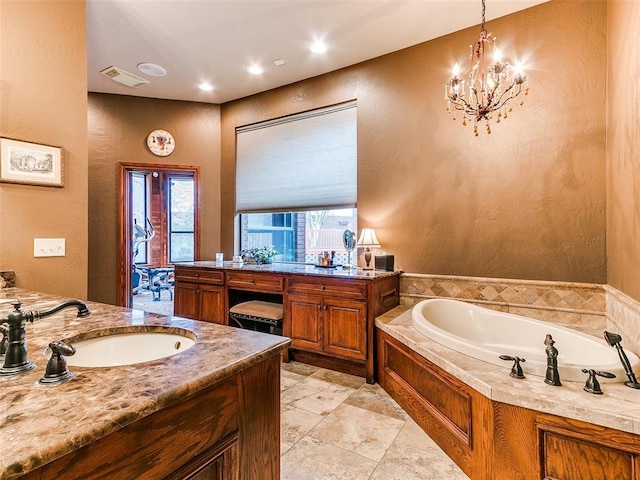 bathroom with a wealth of natural light, a bathtub, and vanity