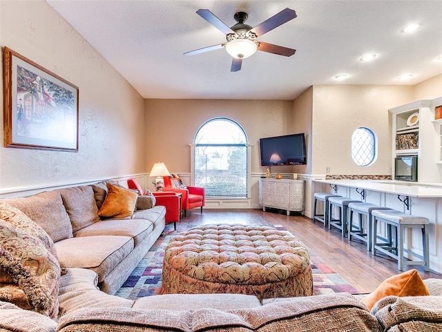 living room with light wood-type flooring and ceiling fan