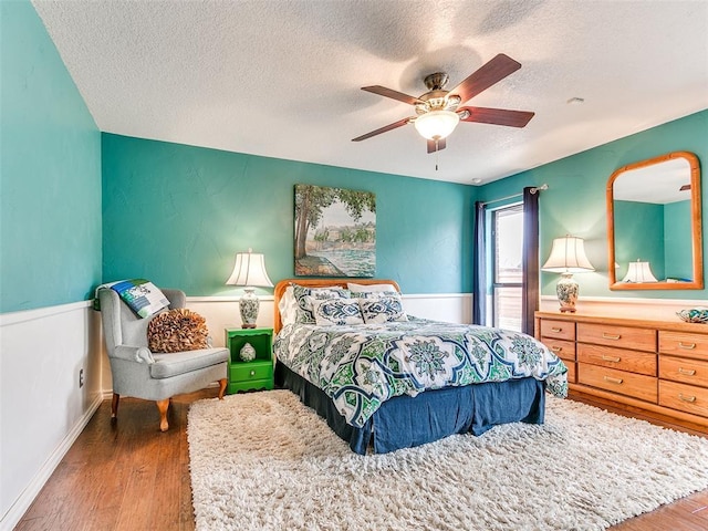 bedroom featuring a textured ceiling, hardwood / wood-style flooring, and ceiling fan