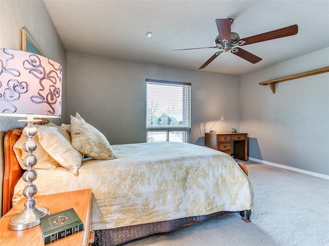 bedroom with ceiling fan, carpet floors, and a textured ceiling