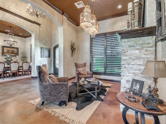 living area featuring an inviting chandelier, crown molding, concrete floors, and a towering ceiling