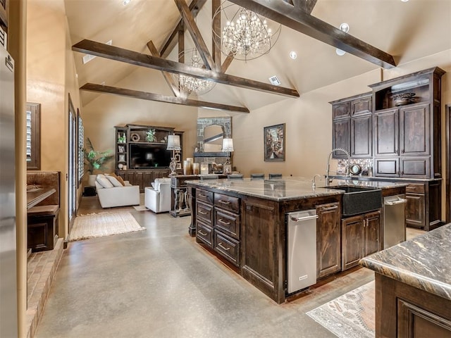 kitchen featuring dark stone counters, a kitchen island with sink, a notable chandelier, dark brown cabinetry, and beam ceiling