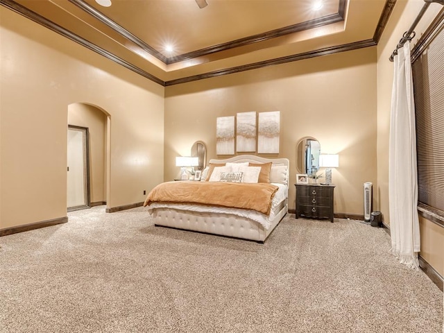 carpeted bedroom featuring crown molding, a raised ceiling, and ceiling fan