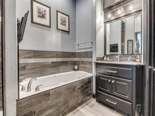 bathroom featuring vanity and tiled tub