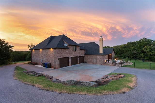 property exterior at dusk featuring a garage