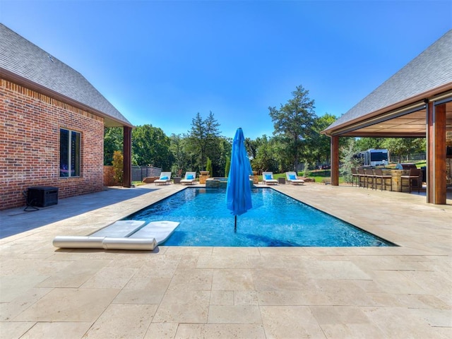 view of pool featuring a bar and a patio