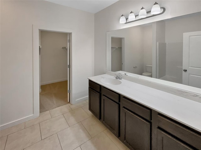 bathroom featuring walk in shower, tile patterned floors, vanity, and toilet