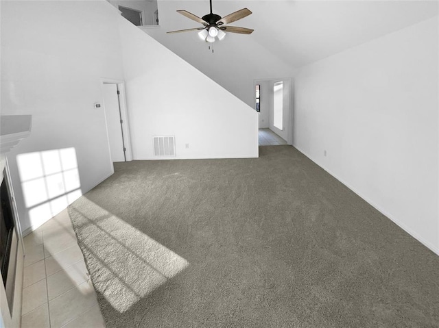 unfurnished living room with ceiling fan, carpet floors, and high vaulted ceiling