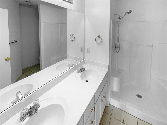 bathroom featuring tile patterned flooring, vanity, and a shower