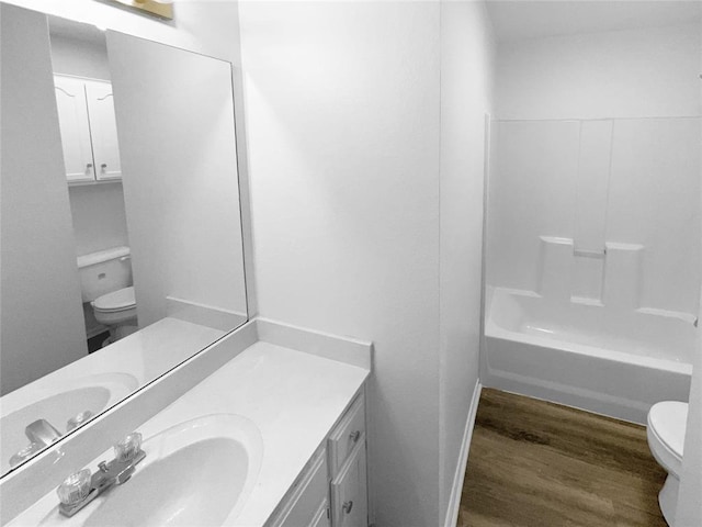 full bathroom featuring wood-type flooring, vanity,  shower combination, and toilet