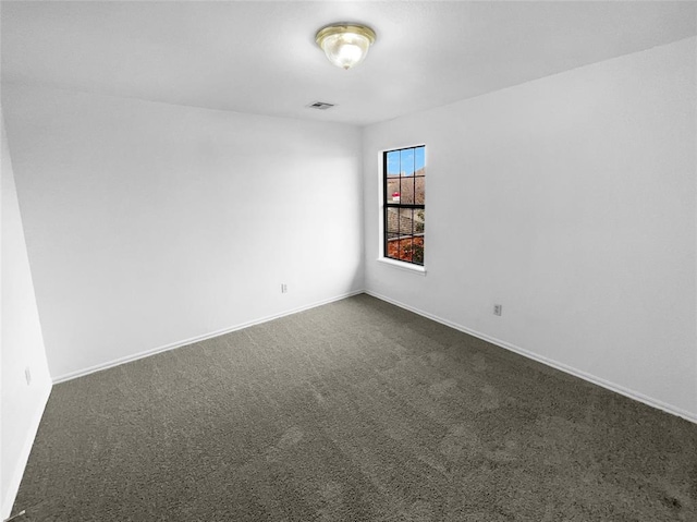 spare room featuring dark colored carpet