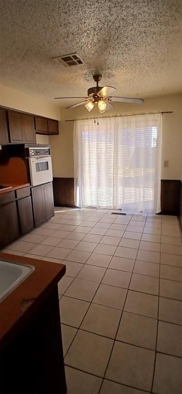 kitchen with oven, a healthy amount of sunlight, and light tile patterned flooring