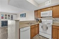 kitchen featuring white appliances and kitchen peninsula