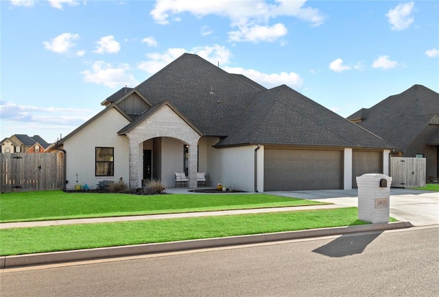 french provincial home with concrete driveway, a front lawn, fence, and an attached garage