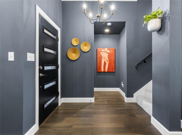 entryway featuring a notable chandelier, dark wood finished floors, baseboards, and stairway