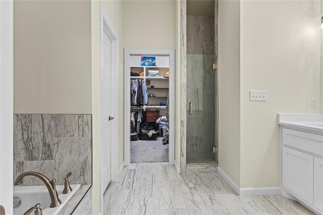 2802 Cloud Nine Cir, Weatherford, OK 73096 - full bathroom with a spacious closet, marble look tiles, a shower stall, a garden tub, and vanity