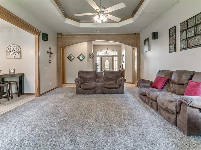 carpeted living room featuring crown molding, a raised ceiling, and ceiling fan