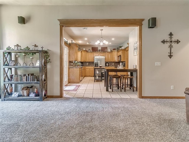 kitchen featuring decorative light fixtures, backsplash, a notable chandelier, stainless steel fridge with ice dispenser, and light carpet