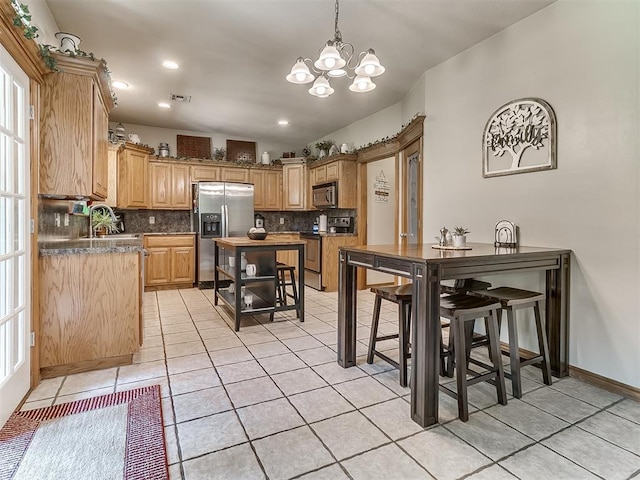 kitchen featuring stainless steel appliances, light tile patterned flooring, sink, and decorative backsplash