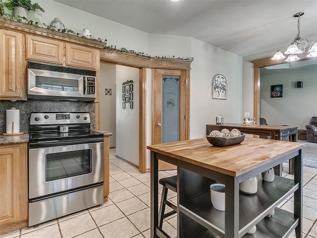 kitchen with light tile patterned flooring, tasteful backsplash, wooden counters, a notable chandelier, and stainless steel appliances