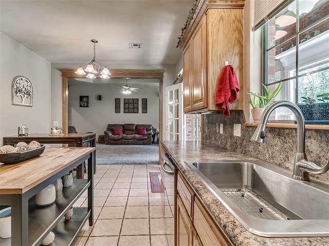 kitchen featuring light tile patterned flooring, butcher block counters, sink, dishwasher, and decorative backsplash