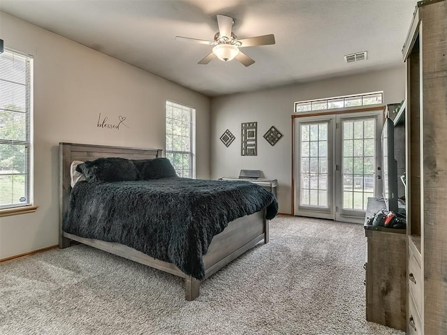 bedroom with multiple windows, access to outside, light colored carpet, and ceiling fan