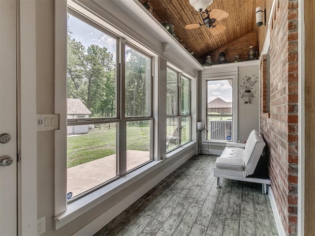 sunroom featuring vaulted ceiling, ceiling fan, and wood ceiling