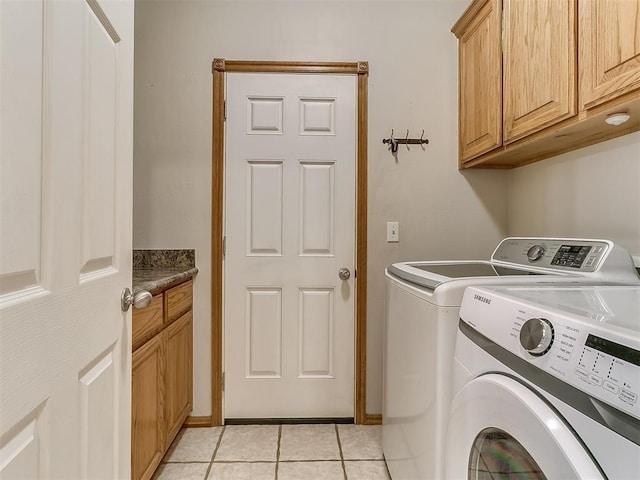 laundry area with cabinets, washer and clothes dryer, and light tile patterned floors