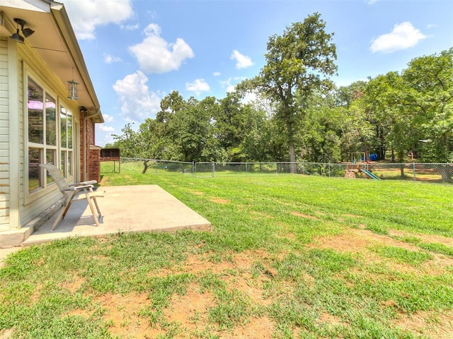 view of yard featuring a playground and a patio