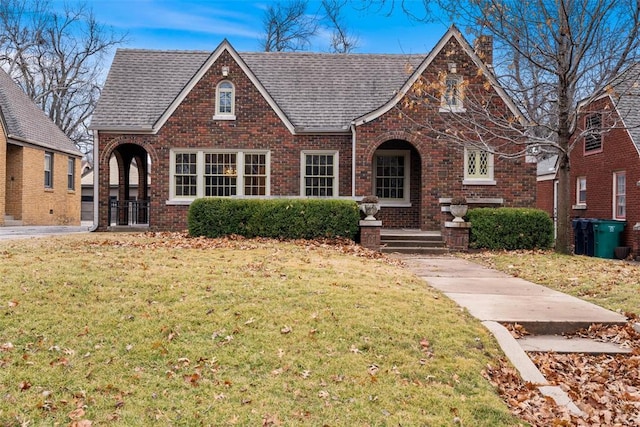 tudor-style house with a front yard