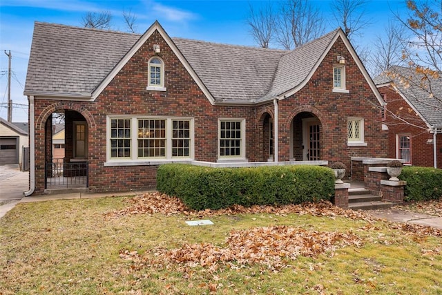 tudor house featuring a garage and a front yard