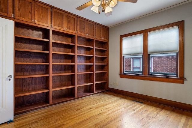 empty room featuring ornamental molding, ceiling fan, and light wood-type flooring