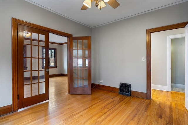 empty room featuring french doors, ceiling fan, crown molding, and light hardwood / wood-style floors