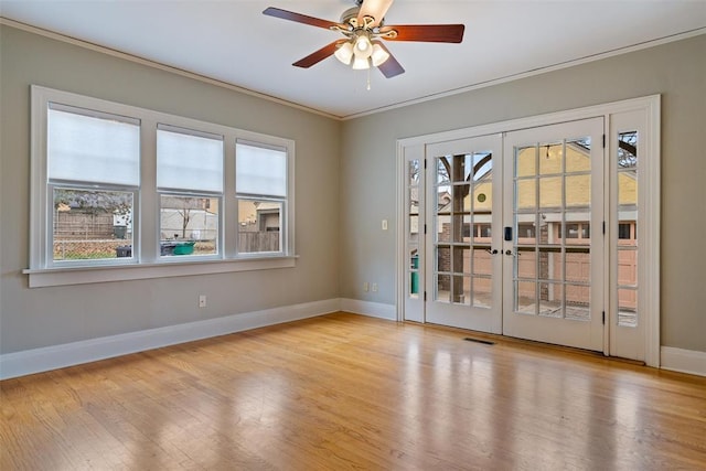 unfurnished room with french doors, crown molding, ceiling fan, and light hardwood / wood-style flooring