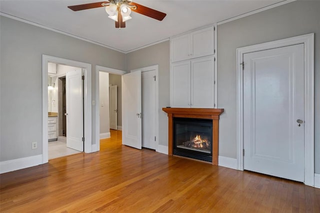 unfurnished living room featuring ornamental molding, ceiling fan, and light wood-type flooring