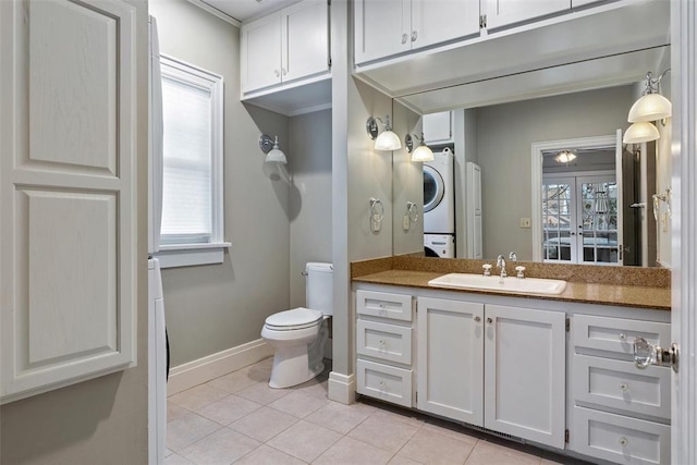 bathroom with vanity, stacked washer / drying machine, a wealth of natural light, and tile patterned floors