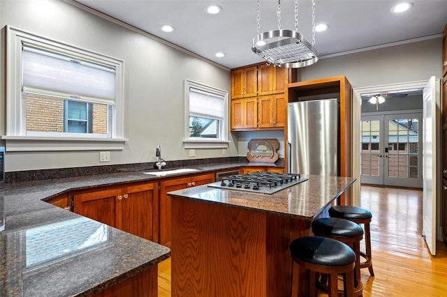 kitchen featuring french doors, sink, crown molding, a kitchen island, and stainless steel appliances