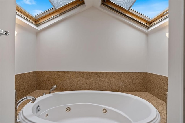 bathroom featuring a washtub and a skylight