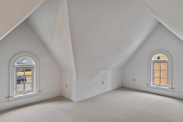 additional living space featuring lofted ceiling and light colored carpet