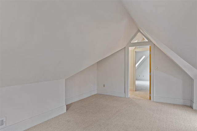 bonus room featuring vaulted ceiling and light carpet