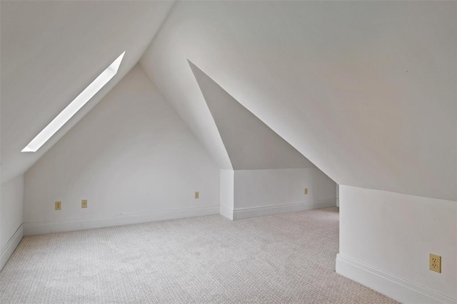 bonus room with lofted ceiling with skylight and light carpet