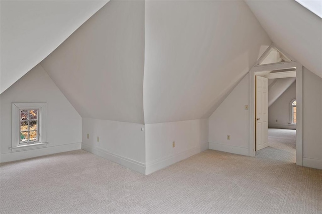 bonus room featuring lofted ceiling and light carpet