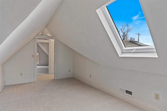 additional living space with light carpet and vaulted ceiling with skylight