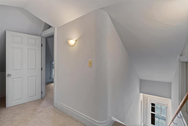 hall with light carpet and lofted ceiling