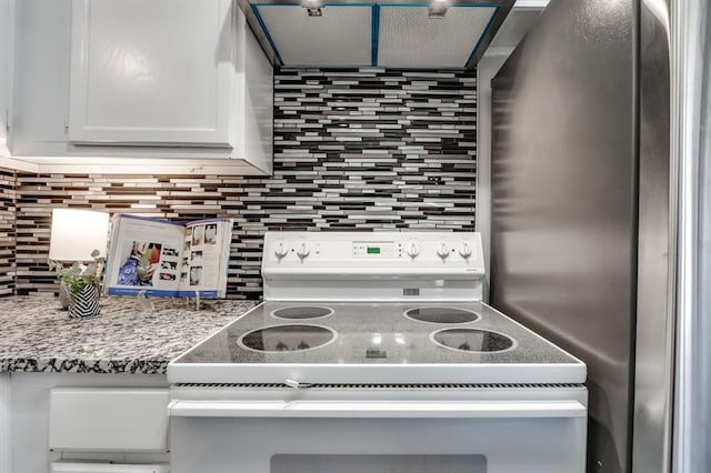 kitchen featuring white cabinetry, light stone countertops, decorative backsplash, and electric stove