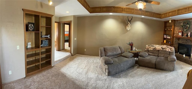 home theater with ceiling fan, carpet floors, built in features, and a fireplace