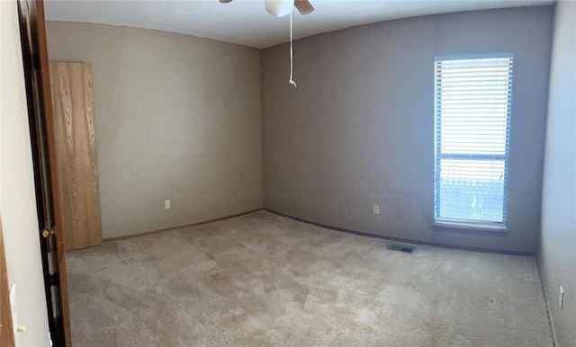 spare room with ceiling fan and light colored carpet